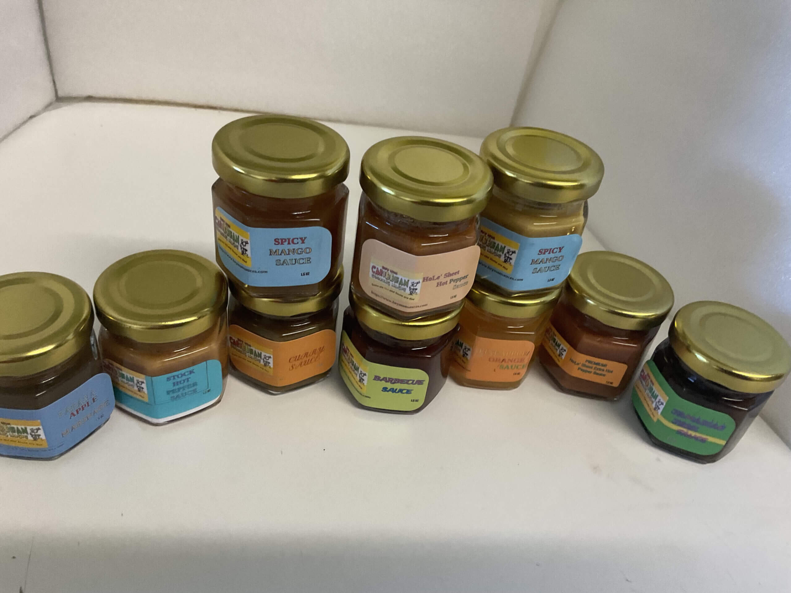 Jars of assorted sauces on a shelf.